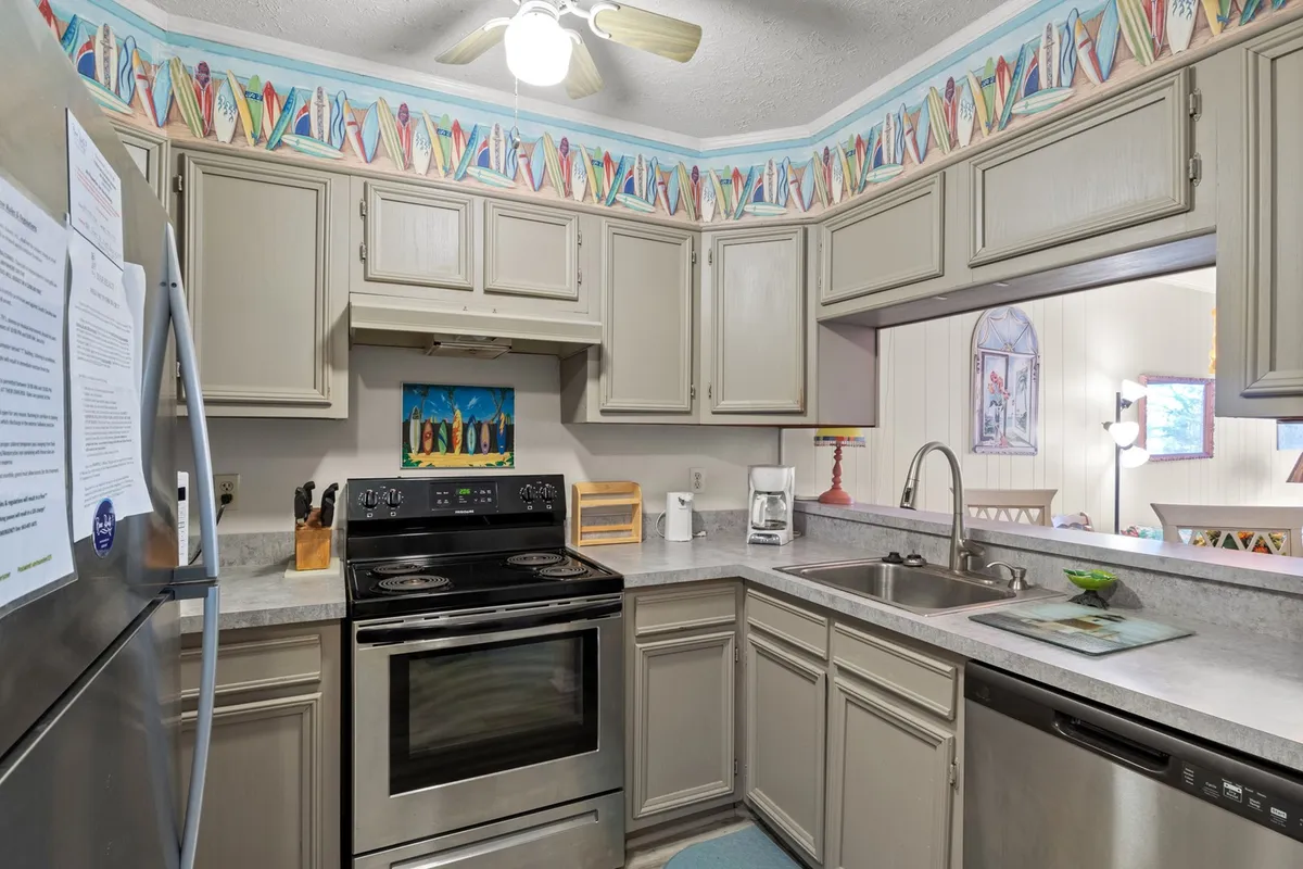This image presents another angle of the kitchen, focusing on the sink area, additional appliances, and a colorful border. The layout appears open and user-friendly, with plenty of counter space.